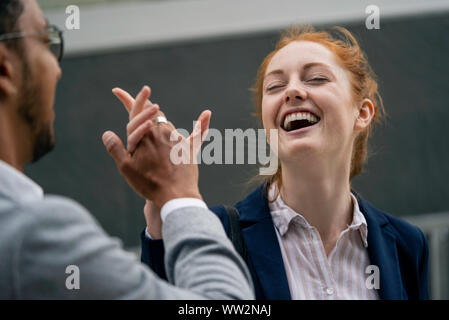 Couple giving-high five outdoors Stock Photo