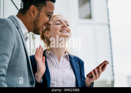 Couple using smart phone outdoors Stock Photo