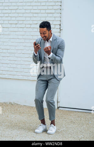 Man using smartphone outdoors Stock Photo