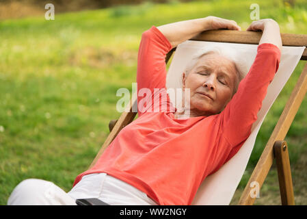 Senior woman relaxing on chair Stock Photo