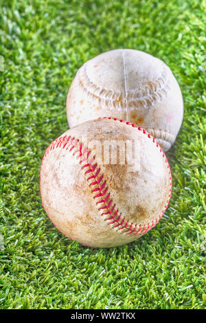 Old baseballs over synthetic grass, vertical HDR image Stock Photo