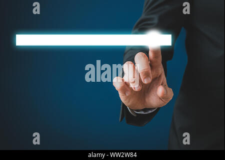 Businessman touching a glowing white search bar on virtual interface in a conceptual image. Over dark blue background. Stock Photo