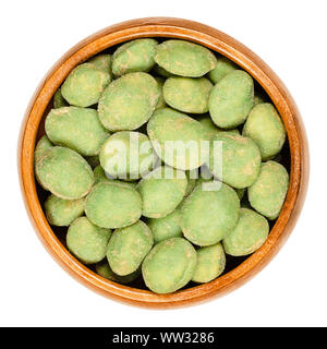 Wasabi peanuts in wooden bowl on white background. Green colored spicy nut snack. Peanuts in rice dough, coated with super hot wasabi powder. Stock Photo