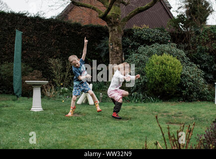 girl and boy dancing outside in the rain together Stock Photo