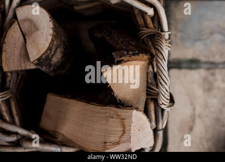 A basket of wooden logs for a fire in the garden Stock Photo