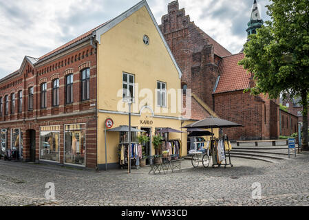 a vintage clothing store with clothes hanging outside the shop, Svendborg, Denmark, 11 July 2019 Stock Photo