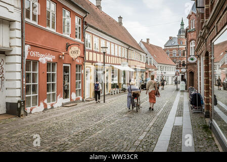 People walking along an old cobblestone street, Svendborg, Denmark, 11 July, 2019 Stock Photo