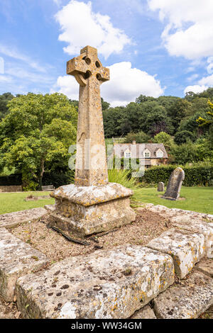 Victorian Celtic churchyard cross on a medieval base in the churchyard of St Michaels church in the Cotswold village of Buckland, Gloucestershire UK Stock Photo