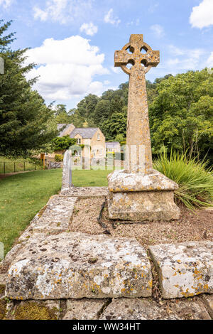 Victorian Celtic churchyard cross on a medieval base in the churchyard of St Michaels church in the Cotswold village of Buckland, Gloucestershire UK Stock Photo