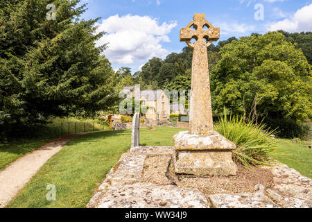 Victorian Celtic churchyard cross on a medieval base in the churchyard of St Michaels church in the Cotswold village of Buckland, Gloucestershire UK Stock Photo