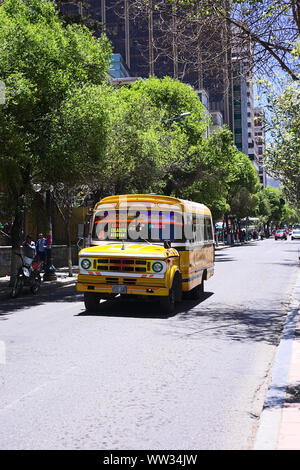 LA PAZ, BOLIVIA - OCTOBER 16, 2014: Old yellow Dodge D400 bus used for public transportation driving on El Prado avenue in the city center Stock Photo