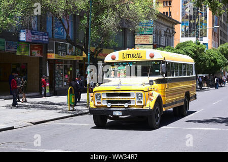 LA PAZ, BOLIVIA - OCTOBER 16, 2014: Old yellow Chevrolet bus used for public transportation driving on El Prado avenue in the city center Stock Photo