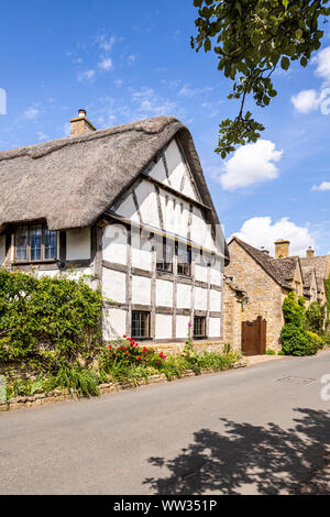 Old half timbered buildings and stone houses beside the lane in the Cotswold village of Stanton, Gloucestershire UK Stock Photo