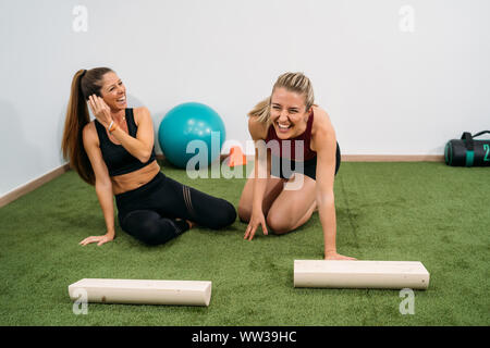 Two smiling and beautiful women with blonde hair do exercises and stretching. Concept of muscle health and relaxation. Portrait Stock Photo