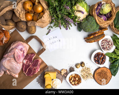 Healthy food for body builders with meat, salmon fish, nuts, cheese, eggs, seeds, beans, vegetables, herbs, spinach, garlic, grains on white backgroun Stock Photo