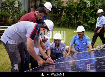 Engineers discussing about the solar photovoltaic cell during a solar power plant traing organised by GERMI in a sunny outdoor. Stock Photo