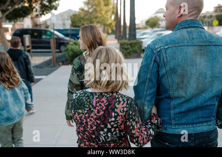 Dad with happy kids walking on sidewalk Stock Photo