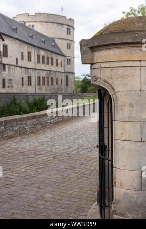 Brick wall of the entrance and main portal into the Wewelburg castle with the large round tower in the background Stock Photo