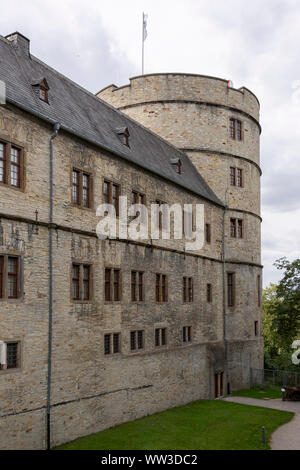 Brick wall of the entrance and main portal into the Wewelburg castle with the large round tower in the background Stock Photo