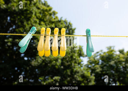coloured pegs hanging on a washing line in an english country garden Stock Photo