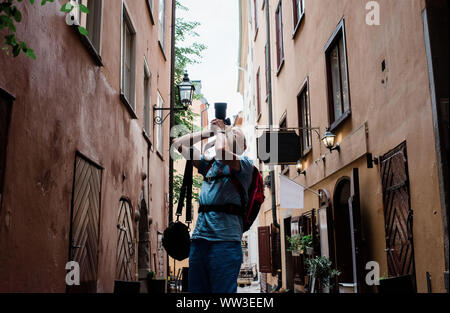 older man taking pictures with a DSLR of a city as a tourist Stock Photo