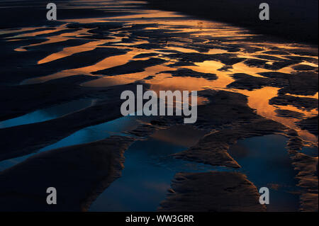 Tide pool abstract, landscape pattern on beach just after sunset Stock Photo