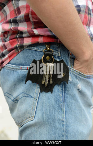 Leather keychain in Bat shape and keys hooked on pants. - image Stock Photo