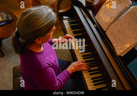 Woman practicing the piano. Stock Photo