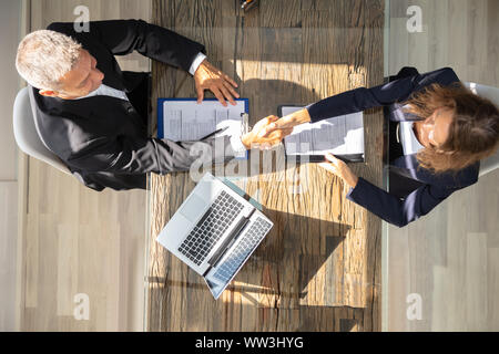 An Elevated View Of A Male Manager Shaking Hands With Female Applicant At Workplace Stock Photo