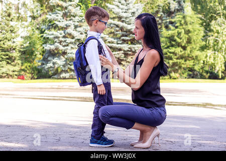 Young brunette mom escorts her first-grader's son to school Stock Photo