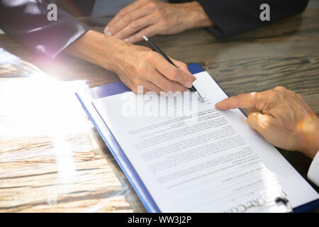 Close-up Of A Real Estate Agent Helping Client In Filling Contract Form Stock Photo