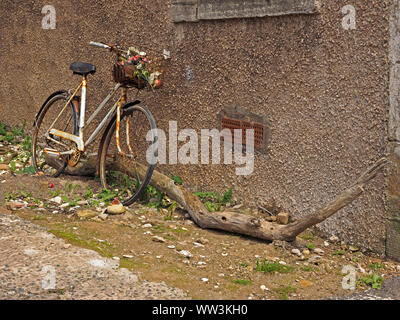 old bicycle leaning against pebbledashed wall with bleached log in the ancient fishing village of Pittenweem, East Neuk,Fife,Scotland,UK Stock Photo