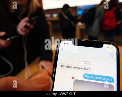 Paris, France - Nov 3, 2017: Customers admiring new Message App inside Apple Store the latest professional iPhone smartphone manufactured by Apple Computers Stock Photo