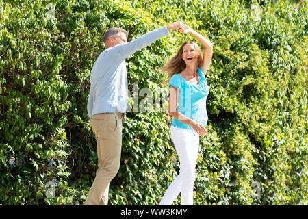 Portrait Of Happy Mature Couple Dancing In Green Park Stock Photo