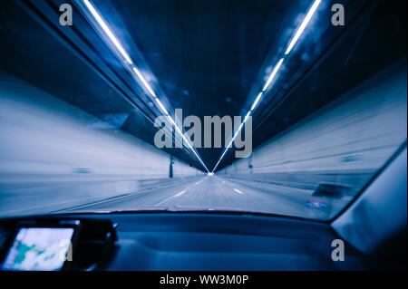 Perspective view fron the car at the long blue tunnel with end at the end Stock Photo