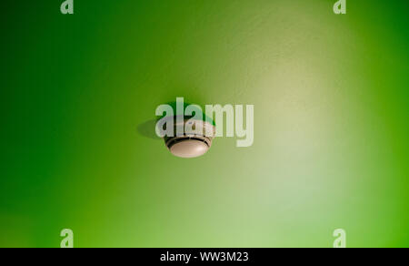 White smoke detector on the green roof in modern luxury hotel apartment office building Stock Photo