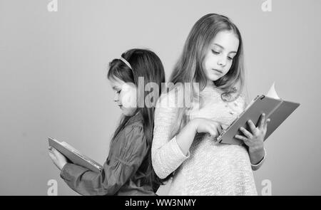 Friendship and sisterhood. students reading a book. School project. workbooks for writing. Back to school. small girls with note books. happy little children ready for lesson. Inspired to work hard. Stock Photo