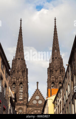 Beautiful, impressive cathedral of Clermont Ferrand in France, made from dark volcanic rocks lighten by golden sunset sun light Stock Photo