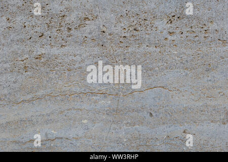 Rough white natural stone travertine with small random cavities. Limestone building material. Stock Photo