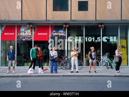 Montreal, Canada. Jul 2019. Canadians at bus stop waiting for public transportation. Stock Photo