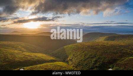 Aerial panoramic view over scenic hills at stormy dramatic sunrise. Shropshire Hills in United Kingdom