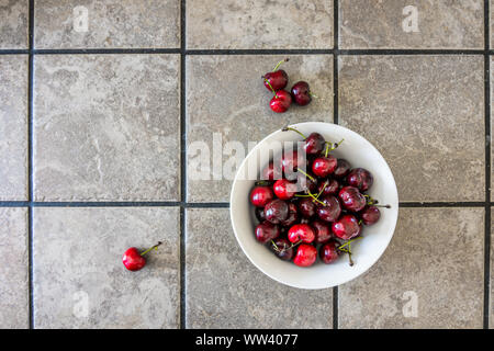 Ripe fresh raw cherries in bowl on ceramic countertop Stock Photo
