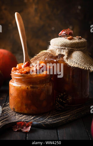 Pumpkin jam on a dark rustic background. Autumn harvest. Cozy autumn still life. Homemade preparations for the winter. Stock Photo