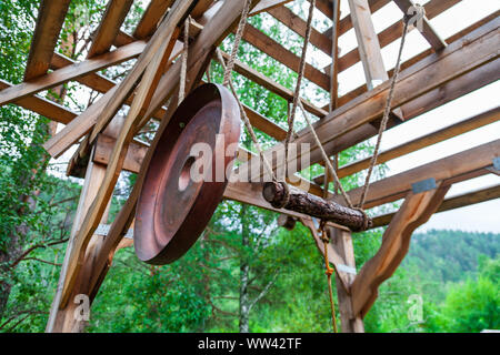 An old retro bronze gong in the form of a circle suspended not on a rope near a bat to signal an attack or event. Concept of old info and messaging. R Stock Photo