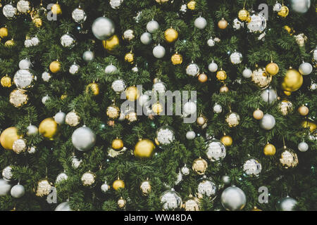 Christmas tree background. Gold and silver balls hanging on the green Christmas tree closeup Stock Photo