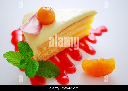 Chocolate cake with physalis fruits, cream, nuts, mousse and mint over white background. Stock Photo