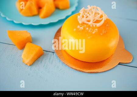 Mousse cake with mango puree, cream and fresh fruits isolated on vintage blue background Stock Photo