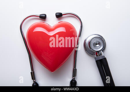 Top View Of Red Heart Shape With Stethoscope Arranged Over Isolated On White Background Stock Photo