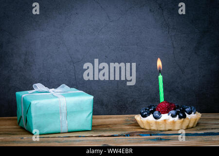Birthday cake with berries and one lighted candle Stock Photo