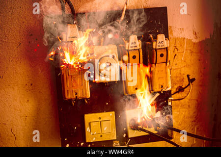 Short circuit fire burn danger of old electrical wire plug and broken circuit breaker Stock Photo